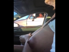 mature woman touches her big boob rolling next to a trucks