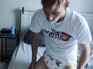 young padded boy with pacifier wears sweet diaper, fills her